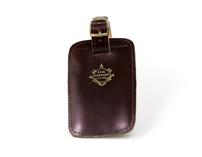 Luggage tag attached to a French horn case, ready for travel.